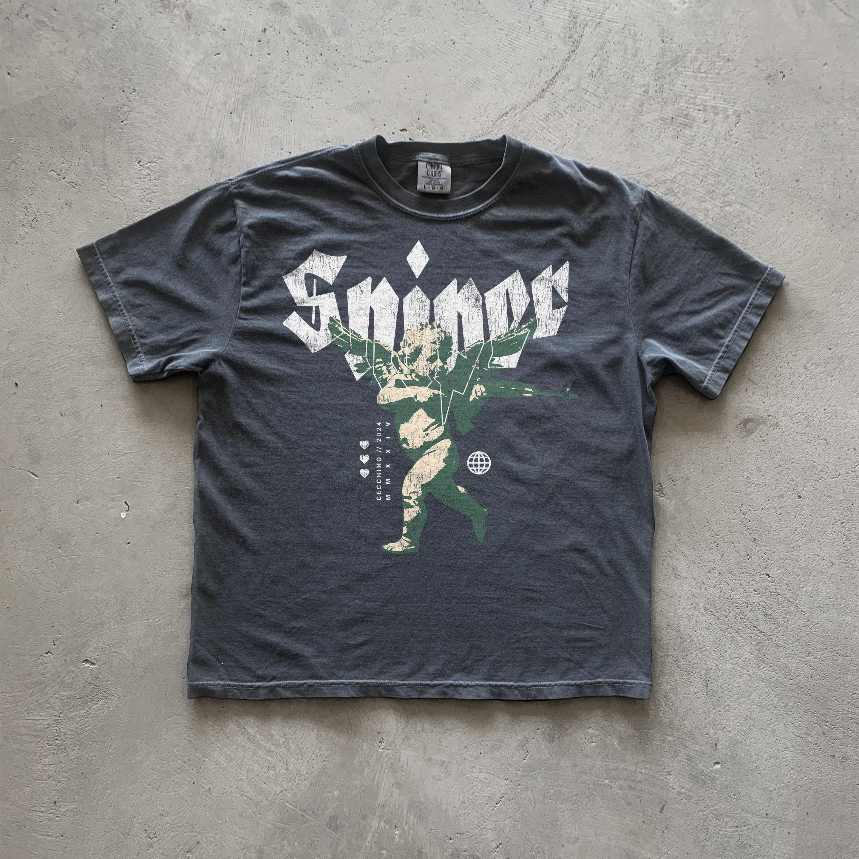 Dark gray t-shirt featuring a vintage-style graphic print of an angel with wings outstretched, holding what appears to be a weapon. The word 'Sniper' is prominently displayed above the angel in stylized, bold lettering.